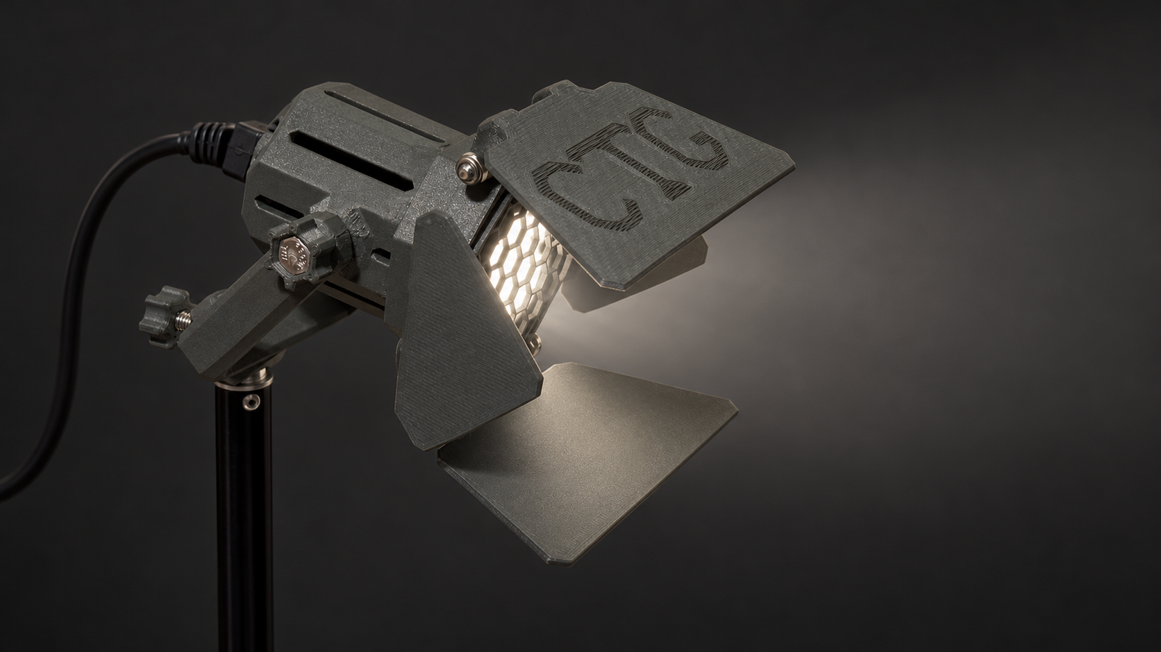 Daylight studio visualization of the gray MiniCine Professional with CTG-marked deep barn doors, honeycomb eggcrate, and a black rear cable